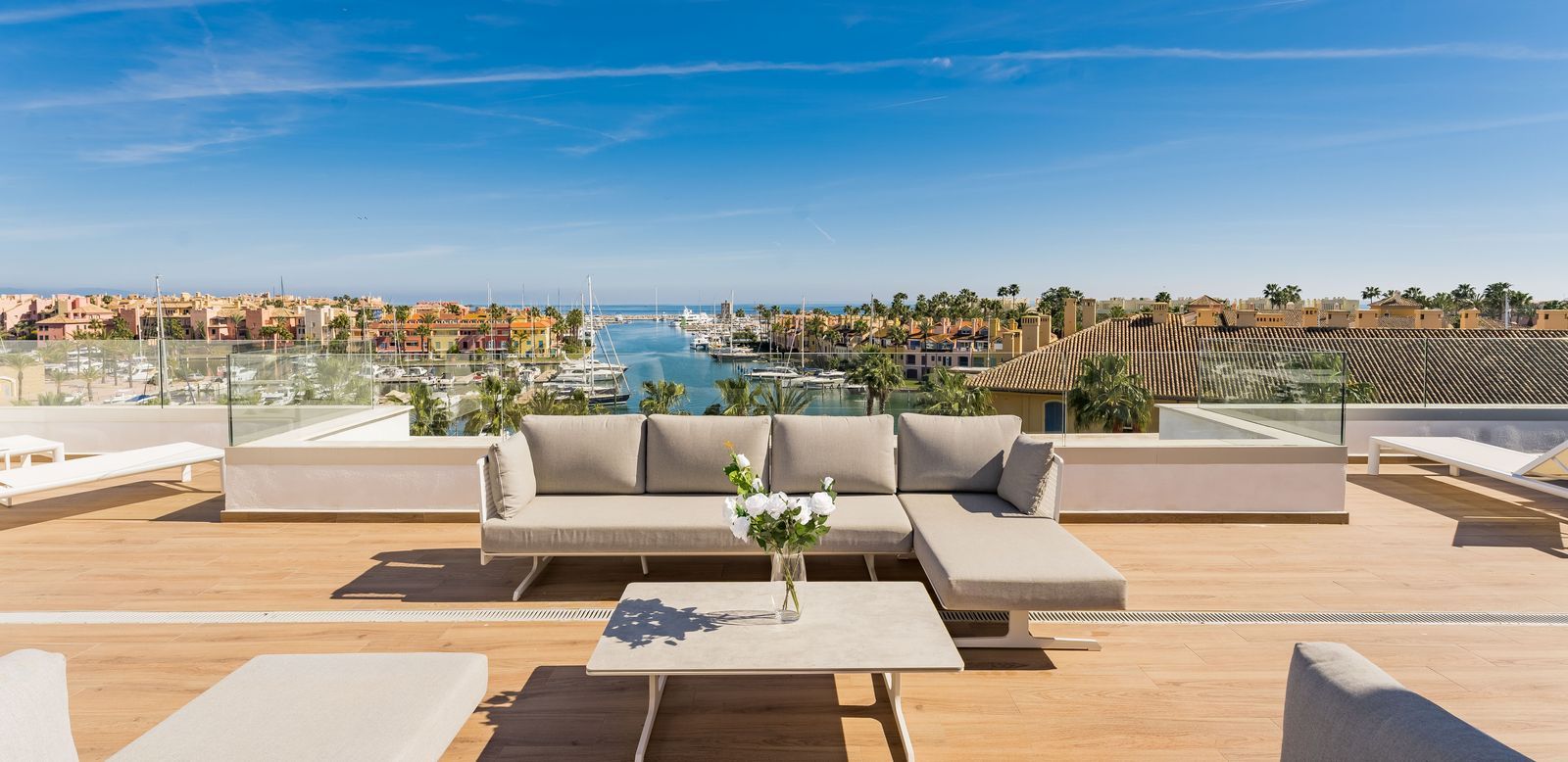  Luxury rooftop terrace overlooking Sotogrande Marina with yachts, Mediterranean views, and elegant outdoor seating.